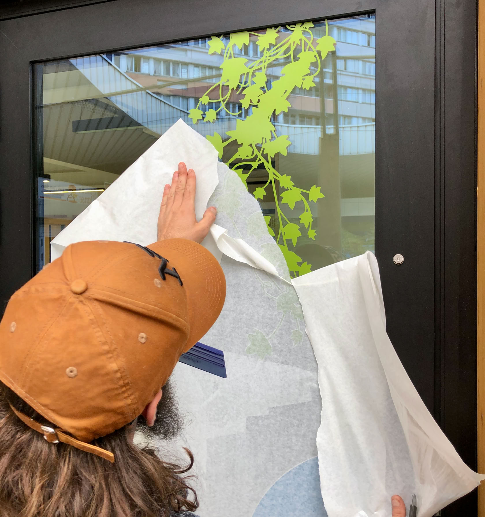 Pose de la signalétique des vitrines TELA 13, la régie de quartier.